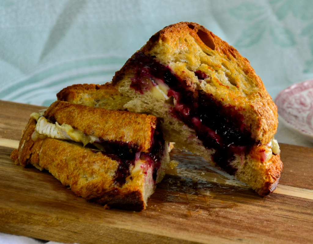 Gourmet grilled cheese with melted brie and haskap jam on toasted artisan bread.