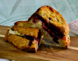 Gourmet grilled cheese with melted brie and haskap jam on toasted artisan bread.