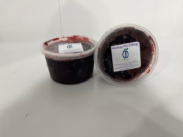 Container of deep purple haskap pie filling made from fresh haskap berries.